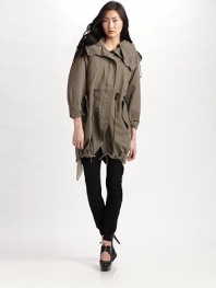 Weather or not, wear this super twill trench for its edge style.Button-off hood with drawstring Stand collar Snap flap over front zipper Drawstring waist Vertical chest pockets Lower flap pockets Cutaway drawstring hem Long sleeves with button tab cuffs Fully lined About 32 from shoulder to hem Cotton; dry clean Imported