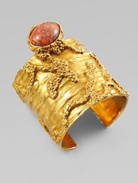 Like a piece of modern sculpture you'd find in a museum, this wide golden cuff combines the intriguing textures of tree bark and rough stone, capped by an oval glass cabochon with a mottled semiprecious look.GlassGoldtoneDiameter, about 2¼Made in Italy