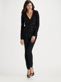 Freeform hearts delineated in shimmering sequins are sprinkled all across the front of a classic cardigan.V neckline Front buttons Long sleeves with ribbed cuffs Ribbed bottom Plain sleeves and back Abut 28 from shoulder to hem 31% nylon/29% viscose/27% cotton/13% wool Dry clean Imported