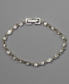 A stunning bracelet with crystal accents in an array of shapes, by Givenchy. Set in silvertone mixed metal. Approximate length: 7-1/4 inches.