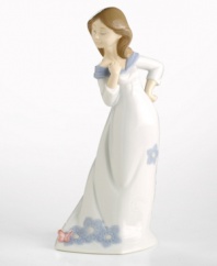 A young woman in a flowing dress admires a butterfly that has landed on her hem. Crafted by Lladró, Spain's most esteemed artisans of porcelain figurines.