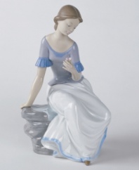 A young woman crouches, deep in thought. Crafted by Lladró, Spain's most esteemed artisans of porcelain figurines.