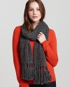 Bundle up in a thick cable knit scarf with long fringed edges.