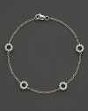 An elegant bracelet crafted from 14 Kt. white gold and adorned with diamond circle stations.