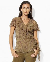 The paisley chiffon Alora wrap blouse is embellished with short flutter sleeves and layered ruffled trim for a feminine flourish.