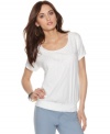 Simple styling with a glam touch: Calvin Klein Jeans' relaxed top features fabric pailettes and a deep scoop neckline.