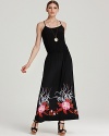 Saturated with dark romance, this DKNY maxi dress showcases an abstract floral motif against a black silhouette.