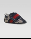 A wide strap in familiar Gucci stripes crosses over a refined sneaker of double G fabric with rich leather accents.GG fabric upperLeather toe, back and accentsWide, striped grip-tape close strapRubber soleMade in Italy