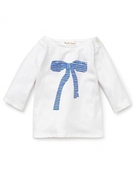A white boat neck Pearls & Popcorn long sleeve tee features a stripe print bow on the front and delicate Mother of Pearl shoulder button closure.
