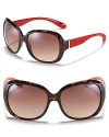 Sleek rounded sunglasses with edgy red logo embossed detail along arms.