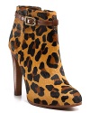 Wrap-around buckles tame fierce leopard print booties, perched on slim, stacked heels. By Tory Burch.