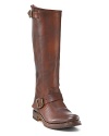 Rustic tall slouchy leather boots in a pull-on style. Adjustable buckle straps at ankle and top. Round toe and 1 raw stacked heel. Banded logo on side of heel. Leather lining and leather sole with rubber tread inset.